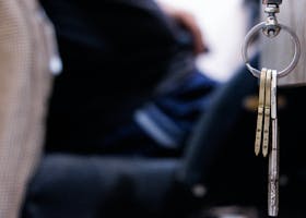 Detailed macro shot of metal keys hanging from a keychain indoors. Perfect for themes of security and lifestyle.