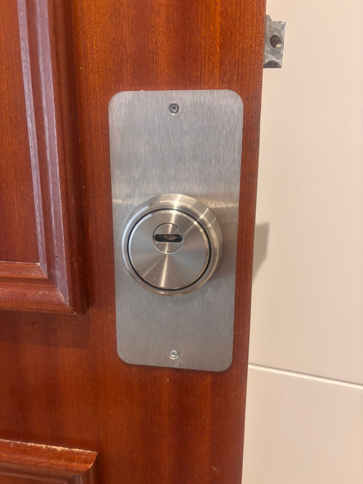 Bombín de seguridad con escudo en puerta madera