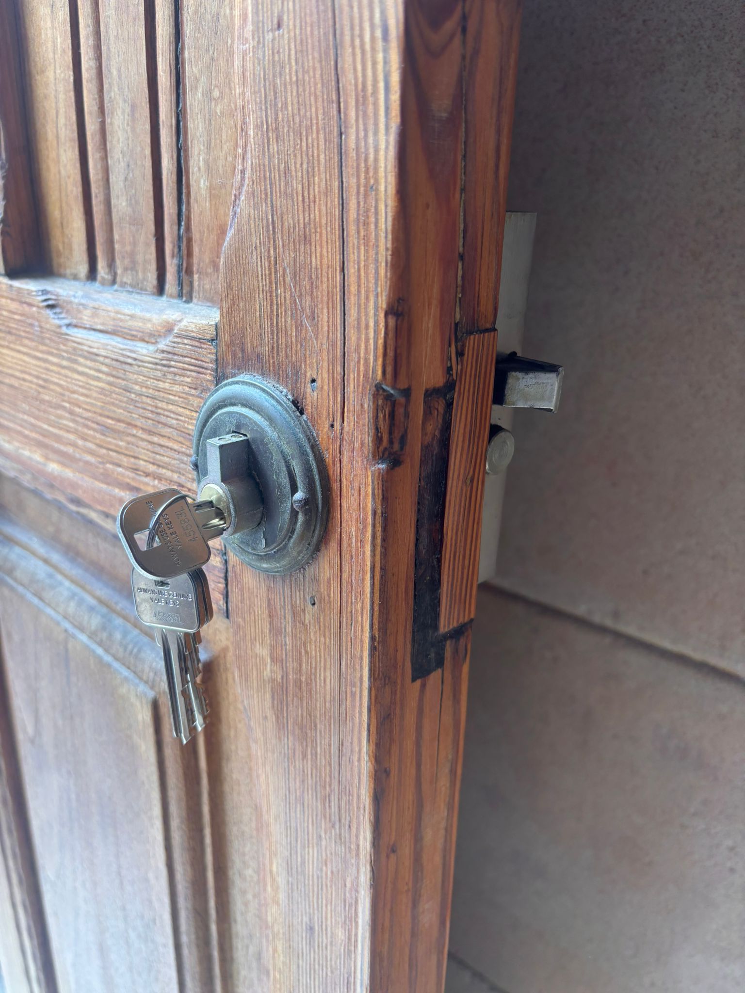 Cerradura de resbalón con llave en puerta de madera